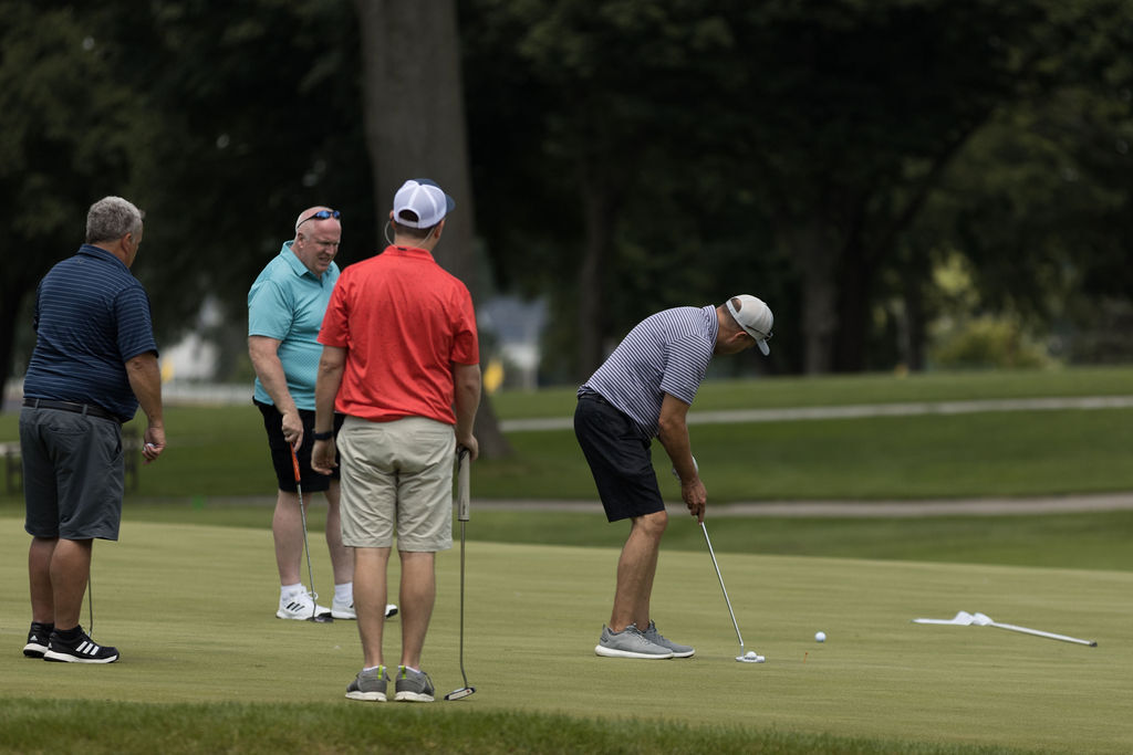 Rodney Boester, John Reilly and Adam Bruner watch Al Ruhrup putt.